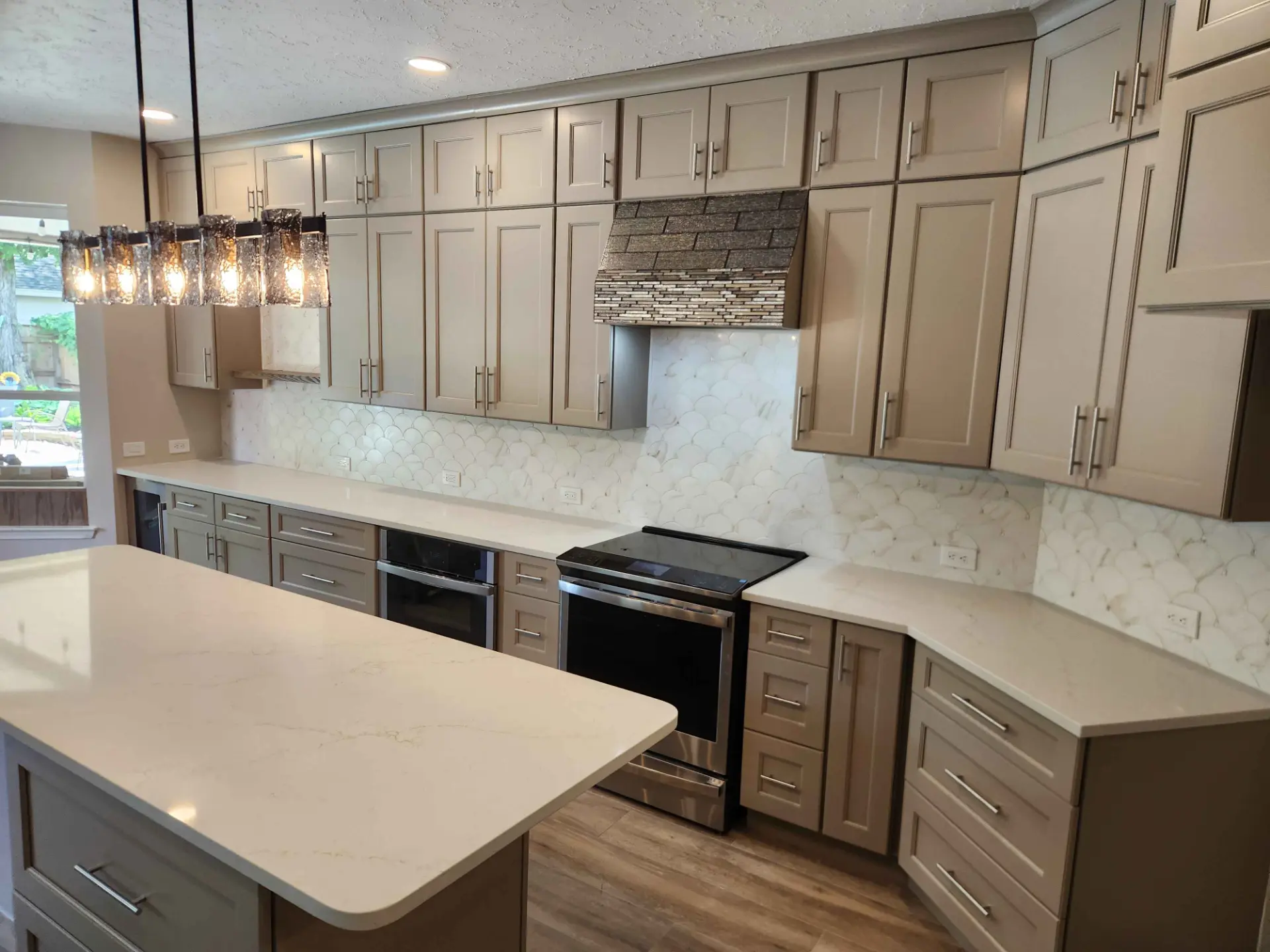 Completed MSS kitchen renovation with greige shaker cabinets, quartz counters, and a scalloped tile backsplash