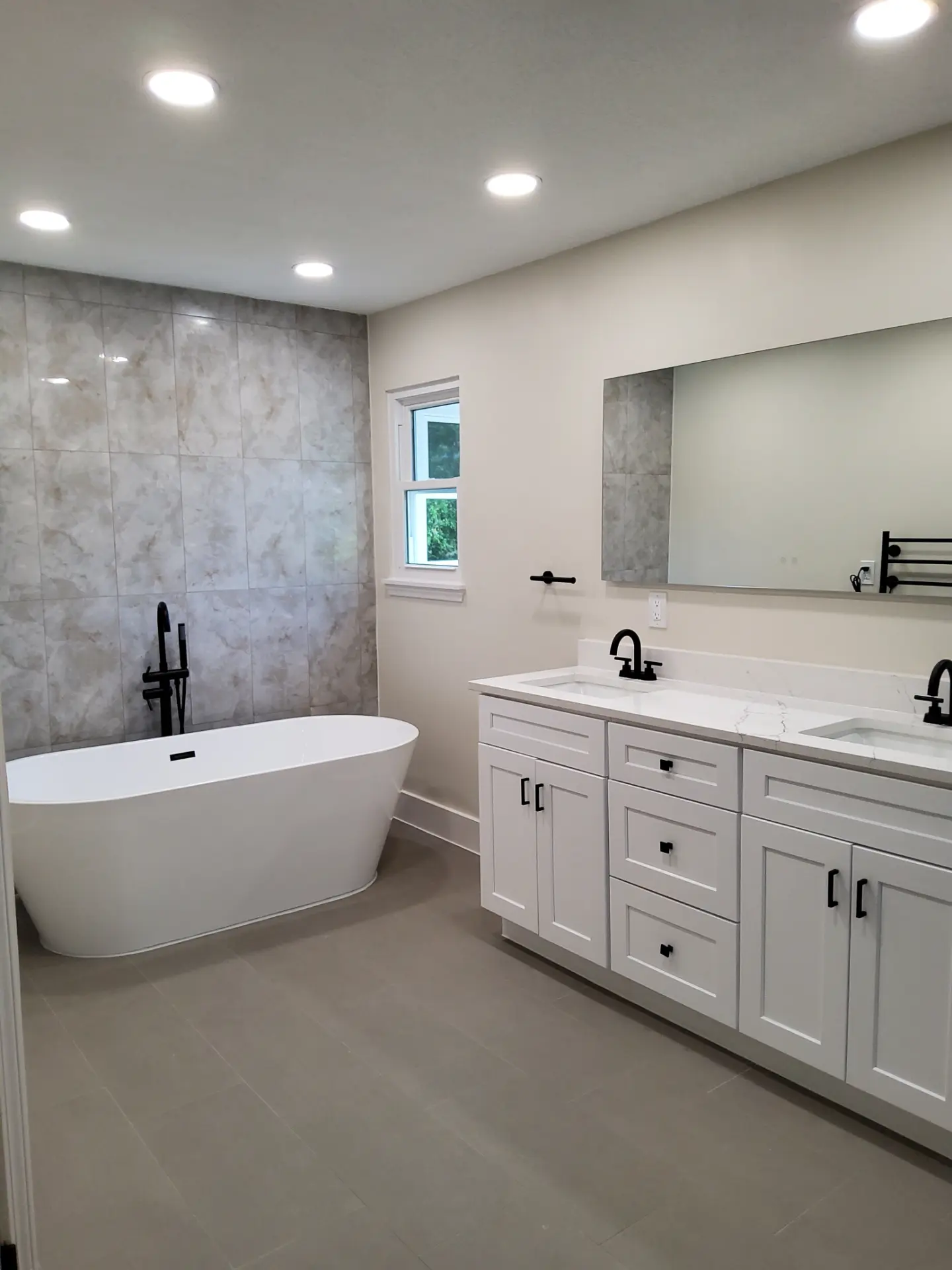 Bathroom after MSS renovation, with a freestanding tub, tiled shower wall, and a new double vanity
