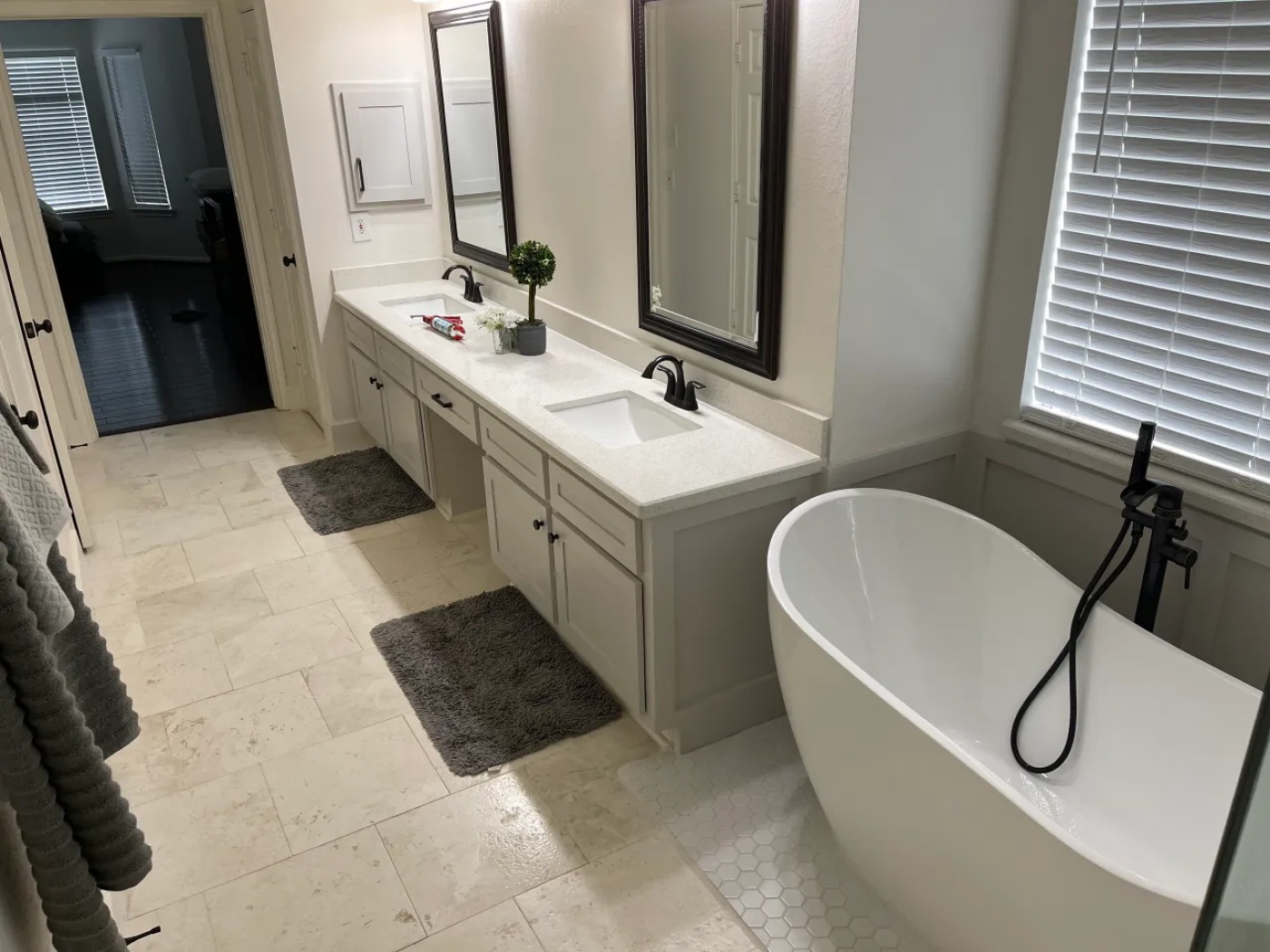 Completed MSS bathroom remodel with a double vanity, freestanding tub, and dark fixtures